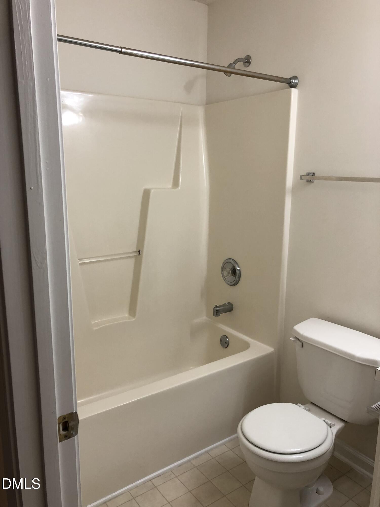 4806 Tapestry Terrace Durham, NC 27713 - Photo 13 of 18 a white toilet sitting next to a bath tub with a shower