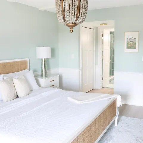 a bedroom with a bed and a chandelier