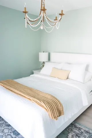 a bedroom with a bed and a chandelier