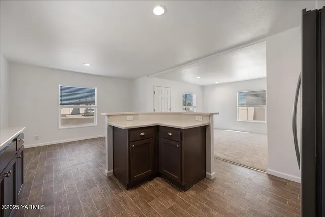 a kitchen with a wooden floor and cabinets