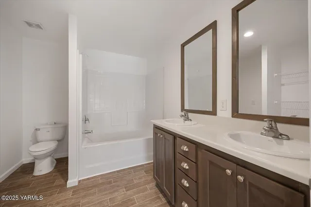 a bathroom with a granite countertop sink a toilet and shower