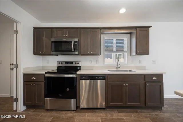 a kitchen with granite countertop a stove and a sink