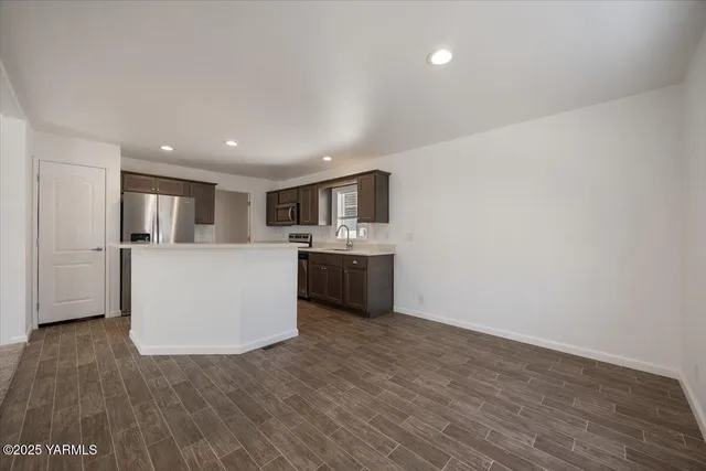 a kitchen with stainless steel appliances a refrigerator sink and white cabinets