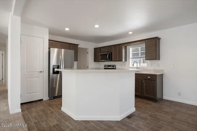 a kitchen with stainless steel appliances a refrigerator stove microwave and sink