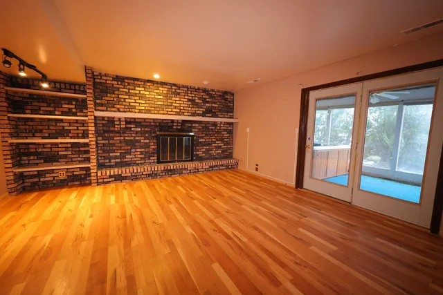 a view of a room with wooden floor