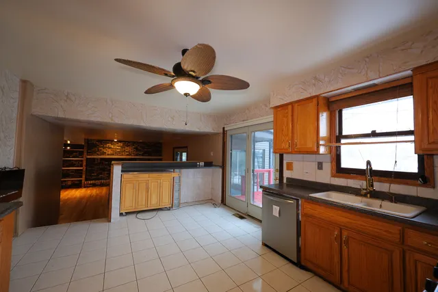 a kitchen with stainless steel appliances granite countertop a sink counter space cabinets and a large window