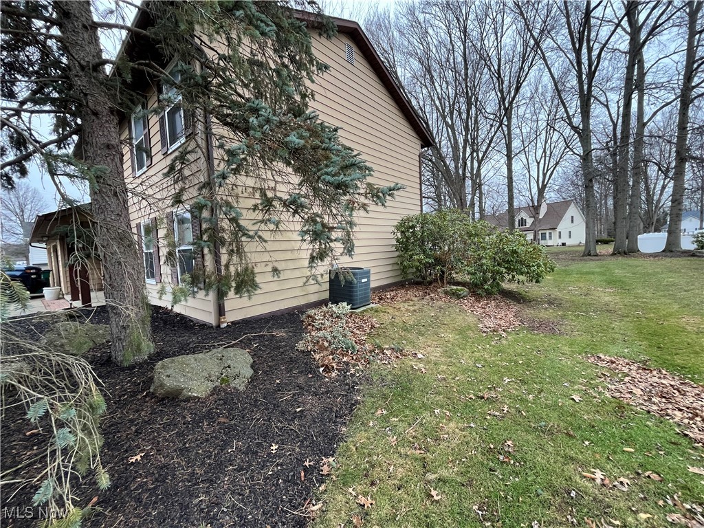 1455 Welch Road Painesville, OH 44077 - Photo 42 of 42 View of side of property featuring a lawn and a central air condition unit