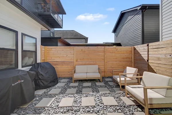 a kitchen with stainless steel appliances granite countertop a stove top oven a sink dishwasher and a refrigerator with wooden floor