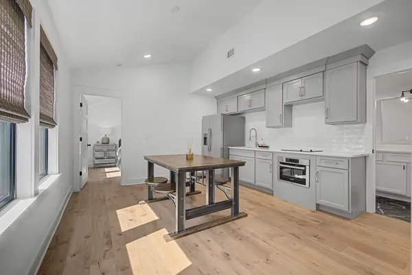a kitchen with a table chairs sink and cabinets