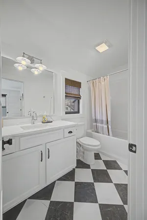 a bathroom with a sink a toilet a mirror and shower