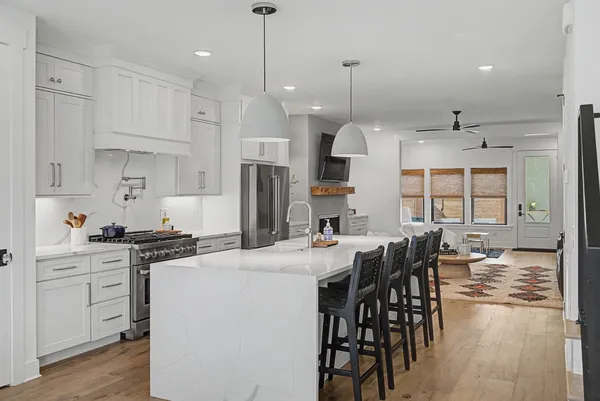 a kitchen with stainless steel appliances kitchen island wooden floors and white cabinets