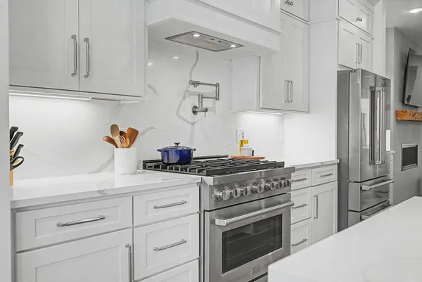 a kitchen with stainless steel appliances white cabinets and a stove