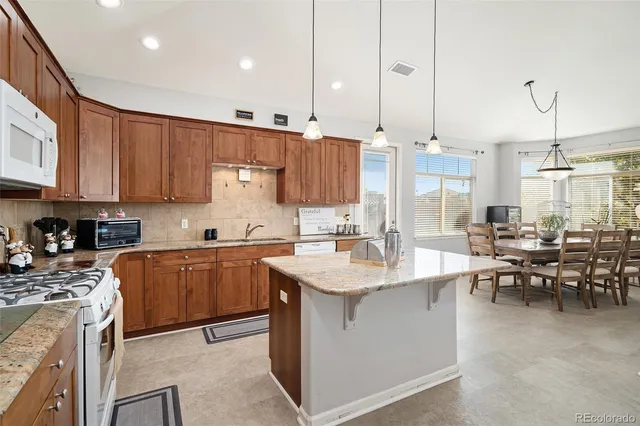 a large kitchen with kitchen island a sink a center island stainless steel appliances and cabinets