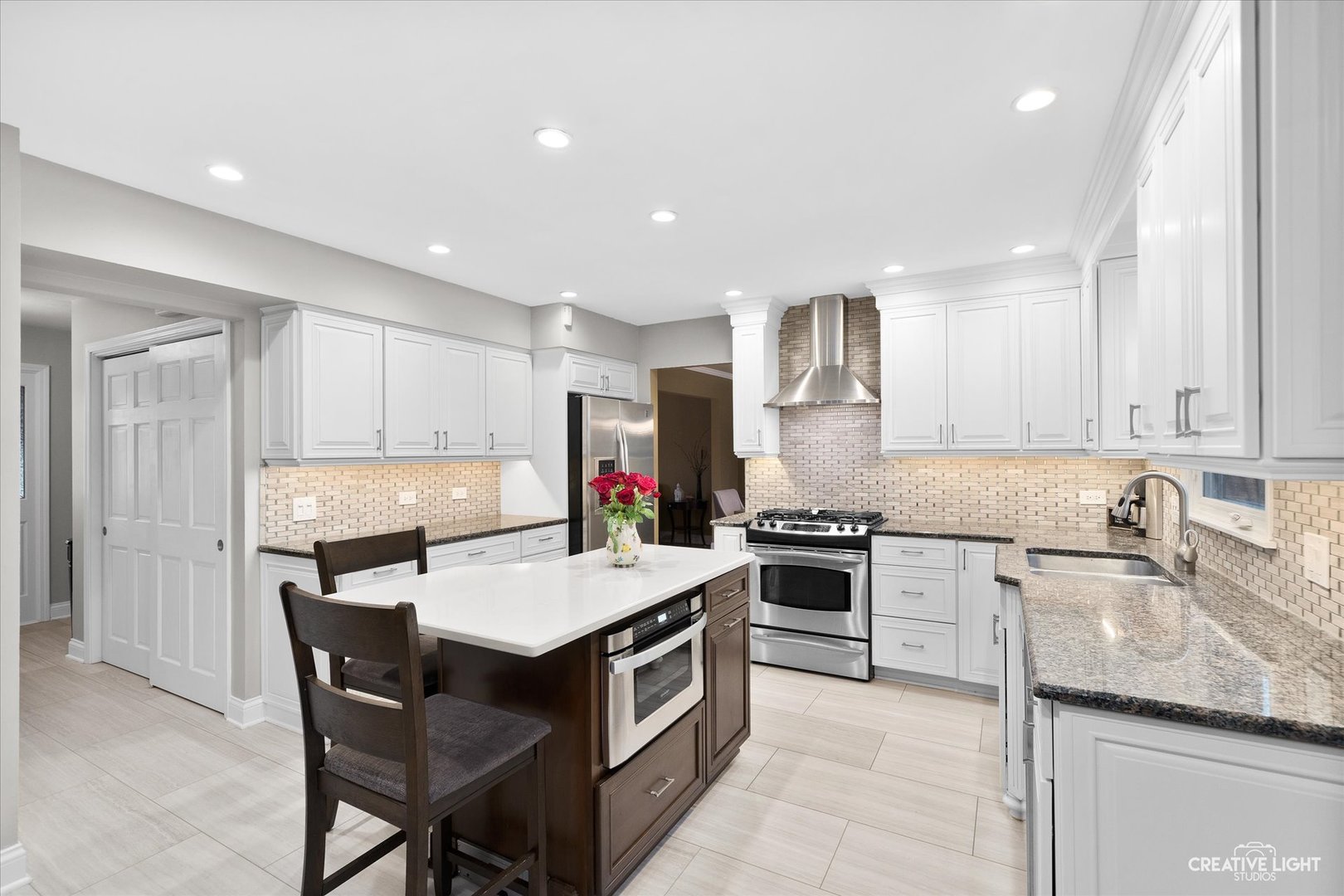 2S541 Seneca Drive Wheaton, IL 60189 - Photo 8 of 28 a kitchen with a stove a sink a kitchen island and chairs