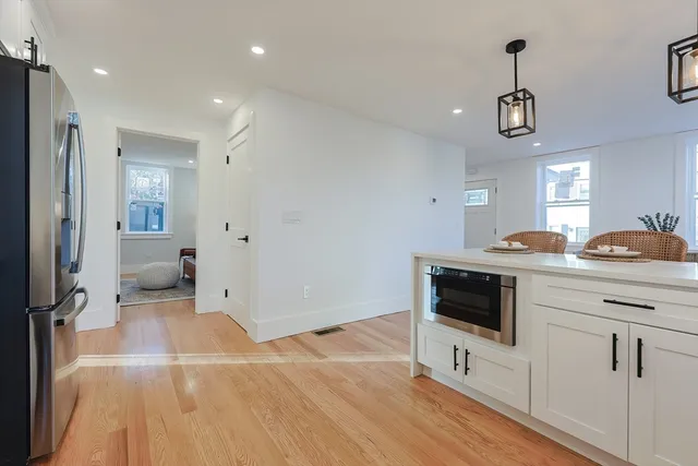 a kitchen with stainless steel appliances a stove a refrigerator and a sink with wooden floor