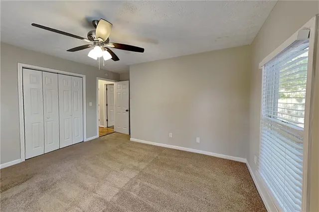 a view of a livingroom with a ceiling fan and window