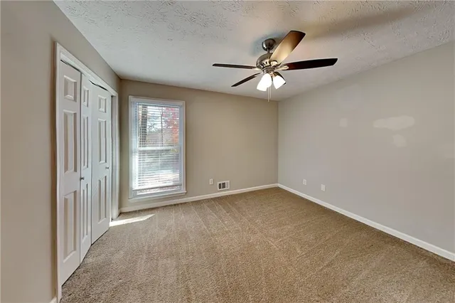 a bathroom with a granite countertop toilet sink and mirror