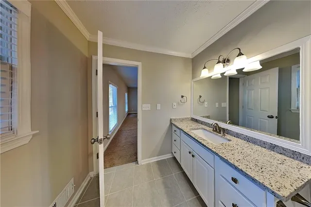 a bathroom with a granite countertop sink a toilet and shower