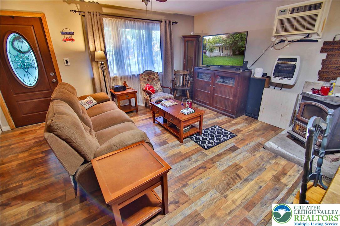 8657 South Loop Road Slatington, PA 18080 - Photo 6 of 32 Warm wood-look laminate flooring and an inviting wood stove anchor this cozy gathering space.