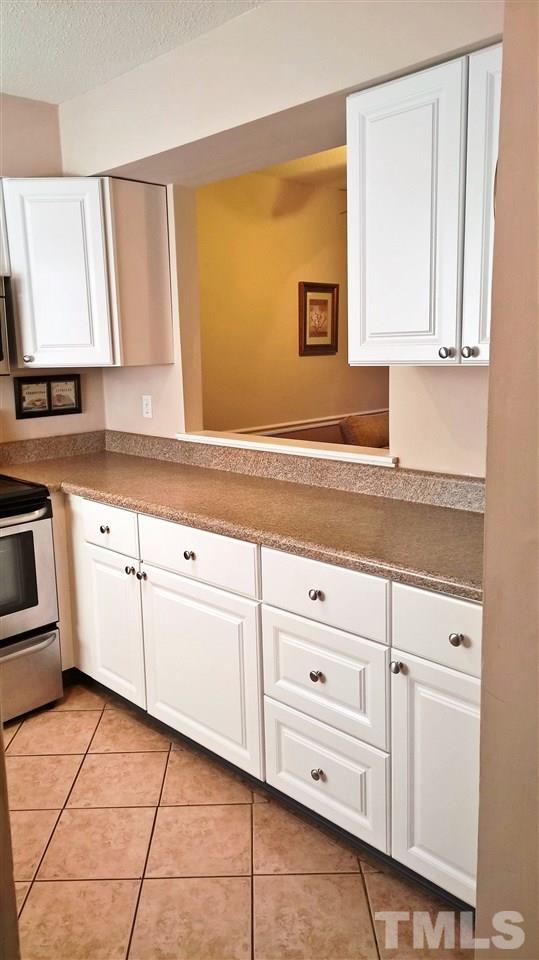 4269 Lake Ridge Drive Raleigh, NC 27604 - Photo 5 of 21 a kitchen with granite countertop white cabinets and white appliances