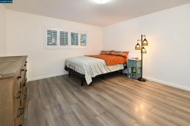 a bedroom with a bed and wooden floor