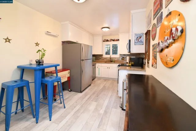 a kitchen with stainless steel appliances granite countertop a refrigerator a stove and a sink