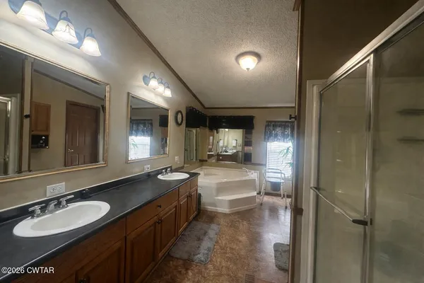 a large bathroom with a granite countertop double vanity sink and a mirror