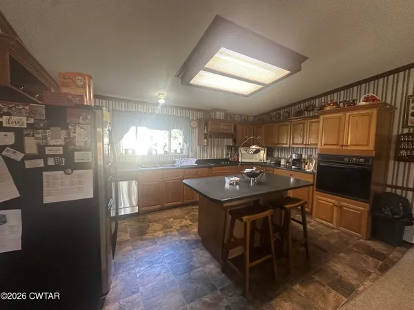a kitchen with kitchen island a sink stove and refrigerator