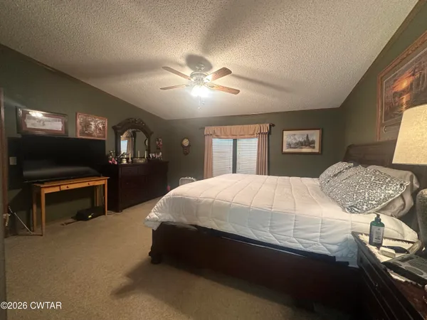 a bed sitting in a bedroom next to a window with a bookshelf