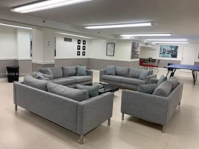 a living room with furniture and a view of kitchen