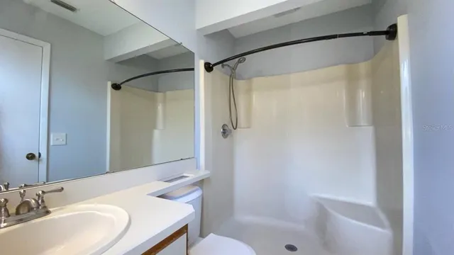 a bathroom with a granite countertop sink toilet and shower