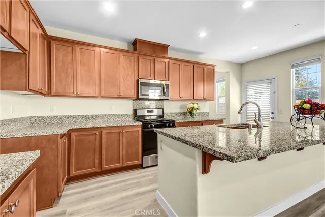 a kitchen with stainless steel appliances granite countertop a stove a sink dishwasher and a microwave oven with granite countertops