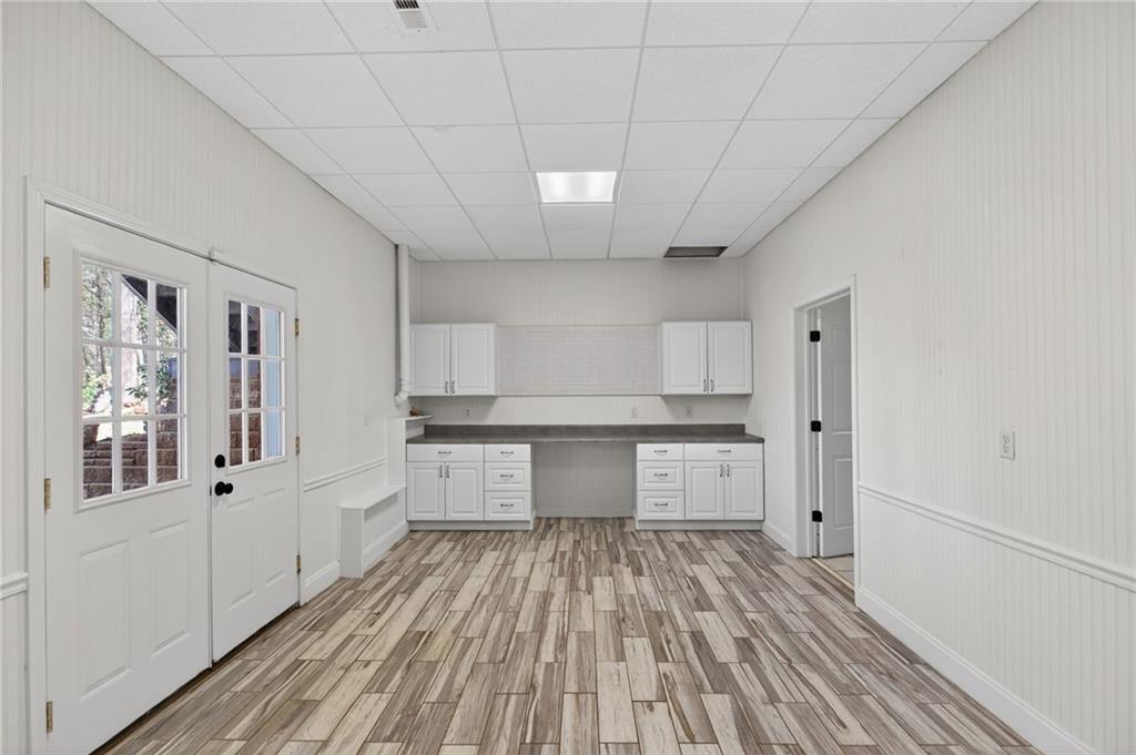 129 Oak Walk Villa Rica, GA 30180 - Photo 43 of 78 a large white kitchen with granite countertop a stove top oven a sink dishwasher and a refrigerator with wooden floor