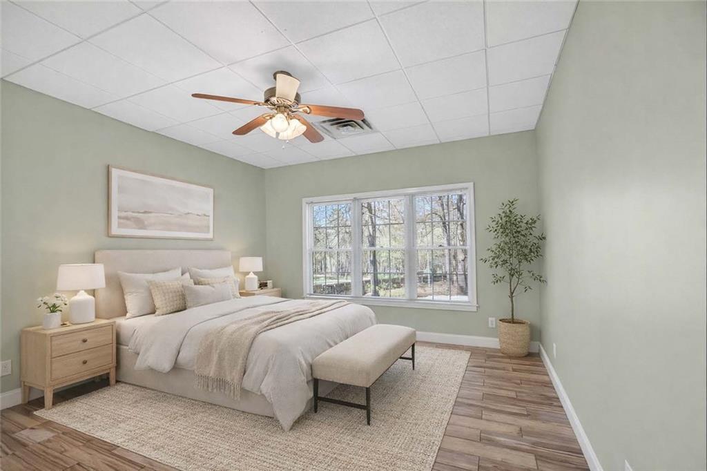 129 Oak Walk Villa Rica, GA 30180 - Photo 57 of 78 a spacious bedroom with a large bed and a chandelier fan