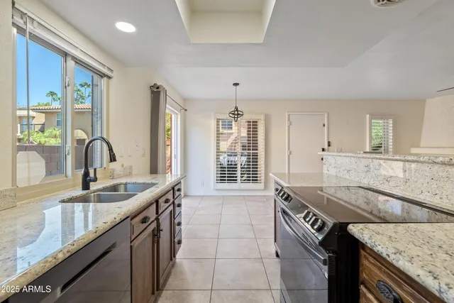 a kitchen with granite countertop a sink and a stove
