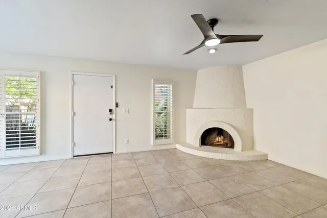 an empty room with fireplace and fan
