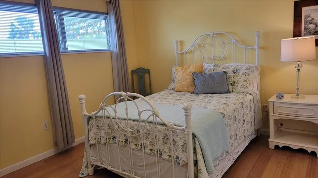 a bedroom with a bed and wooden floor