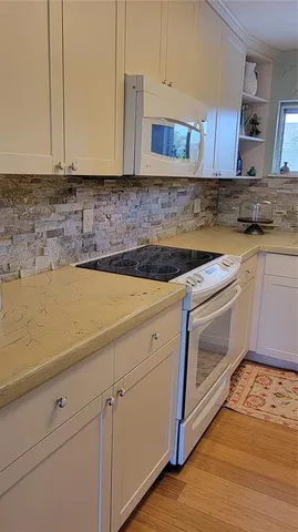 a kitchen with stainless steel appliances granite countertop a sink a stove and cabinets