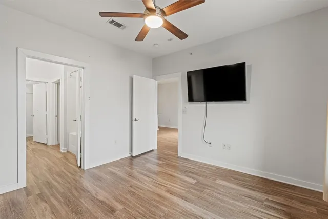 a view of a livingroom with wooden floor and a flat screen tv