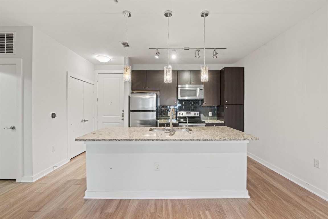 1900 Barton Springs Road, Unit 4037 Austin, TX 78704 - Photo 4 of 34 a view living room with granite countertop kitchen island stainless steel appliances a sink and wooden floor