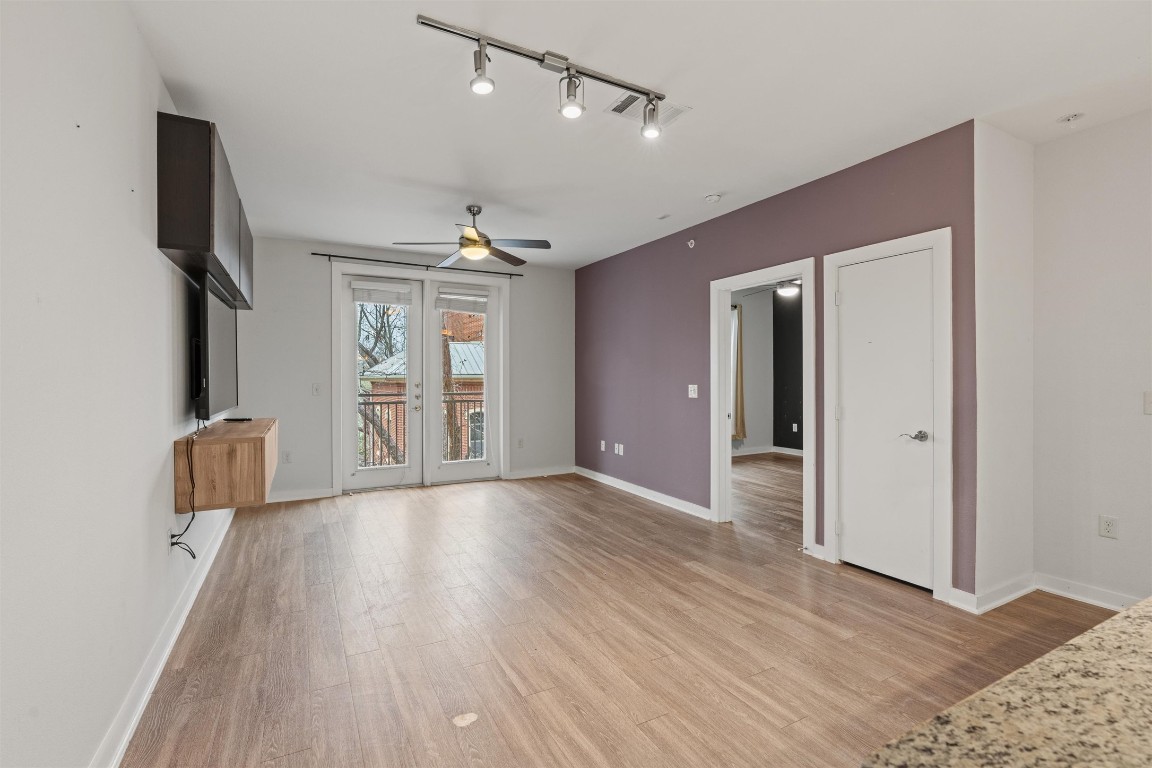 1900 Barton Springs Road, Unit 4037 Austin, TX 78704 - Photo 8 of 34 a view of an empty room with a window and wooden floor
