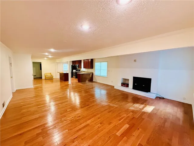 a view of empty room with wooden floor and fireplace