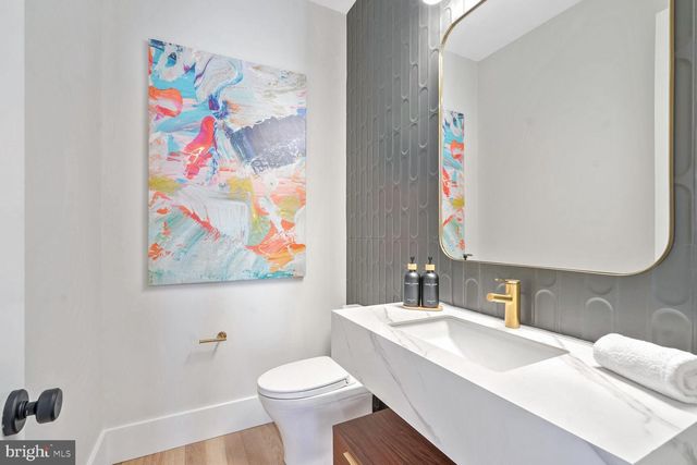 a kitchen with stainless steel appliances kitchen island granite countertop a refrigerator a stove a dining table and chairs with wooden floor