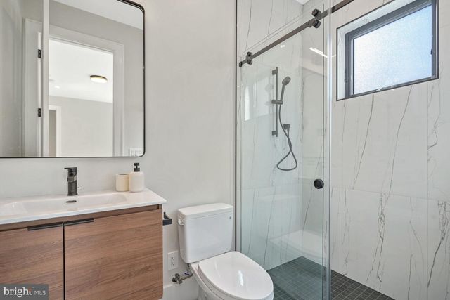 an empty room with wooden floor ceiling fan and windows