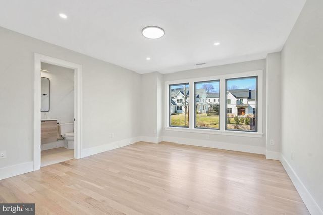a view of a hallway with wooden floor and a white door