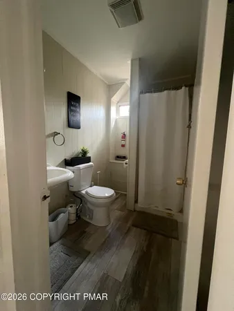 a bathroom with a toilet a sink and mirror