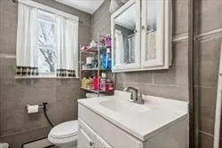 a bathroom with a sink vanity mirror and toilet
