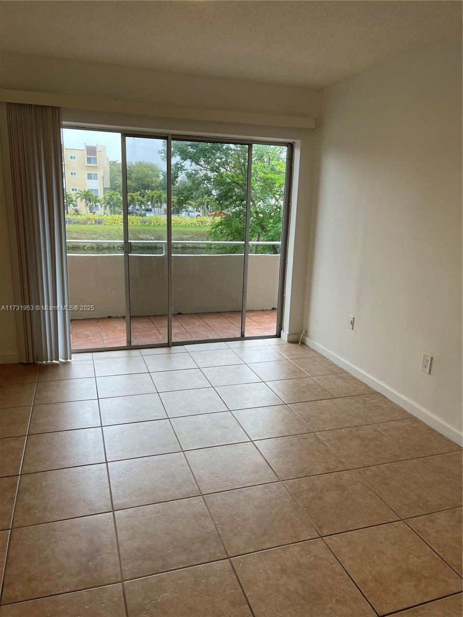 7787 Southwest 86th Street, Unit E211 Miami, FL 33143 - Photo 11 of 27 a view of a livingroom with a floor to ceiling window