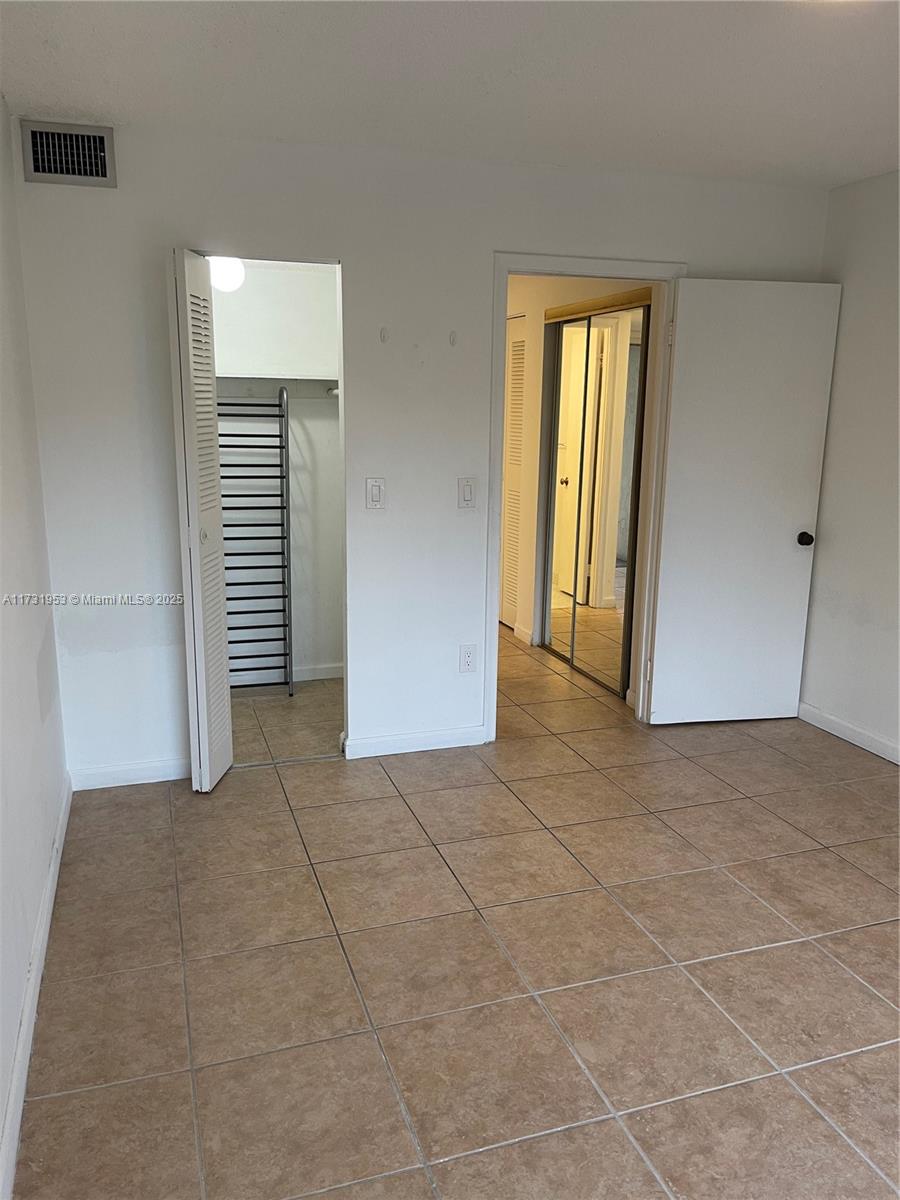 7787 Southwest 86th Street, Unit E211 Miami, FL 33143 - Photo 13 of 27 a view of an empty room with a window