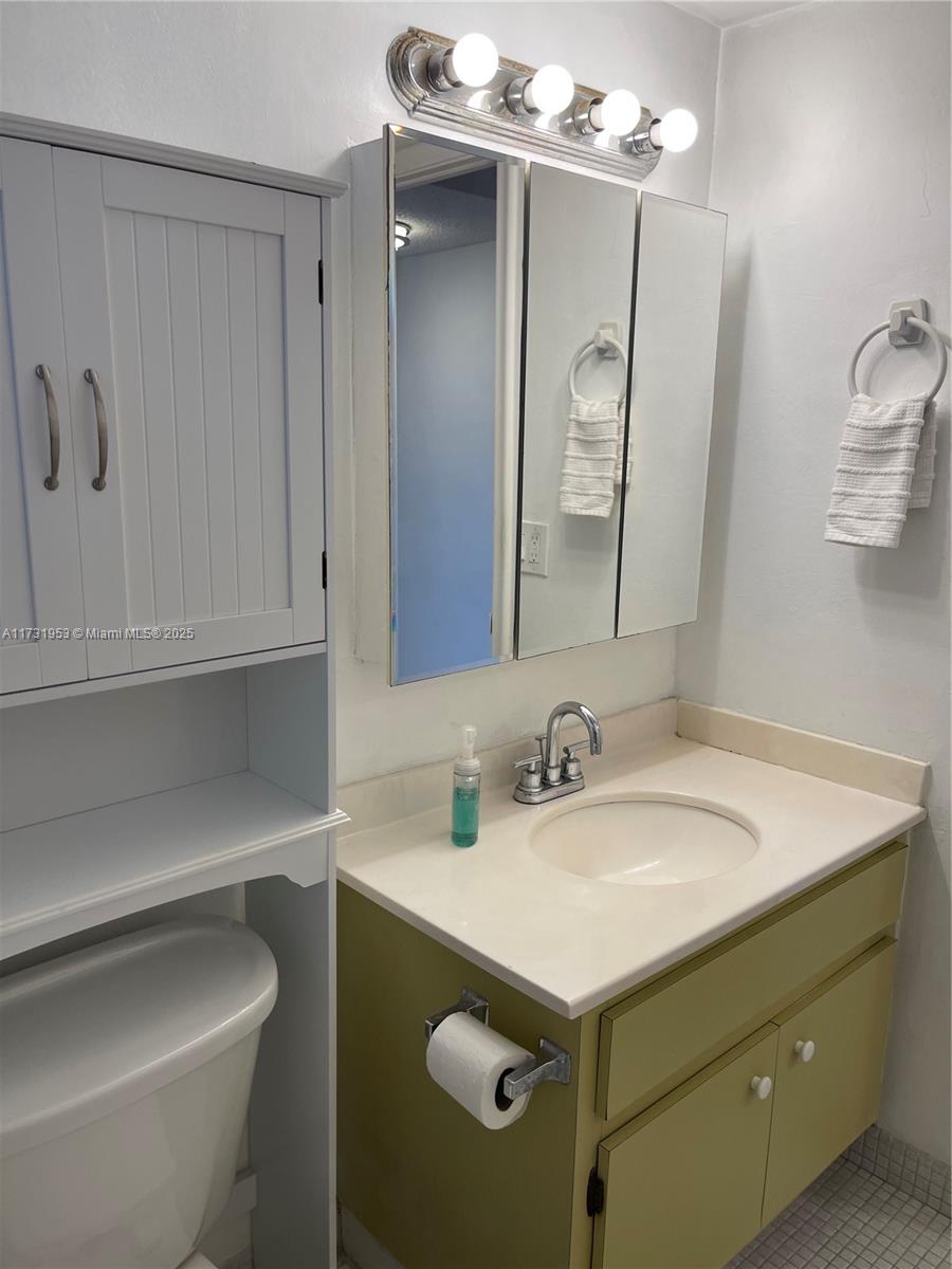 7787 Southwest 86th Street, Unit E211 Miami, FL 33143 - Photo 15 of 27 a bathroom with a sink vanity toilet and a mirror